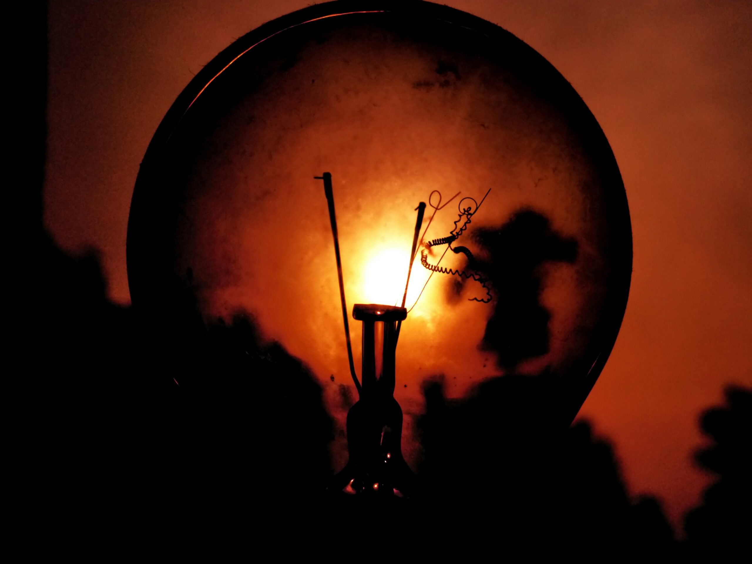 Fotografia de uma lâmpada fundida ao crepúsculo dando a ideia de um ambiente sombrio