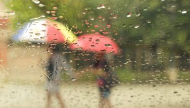Mother and son with umbrella walking in the rain