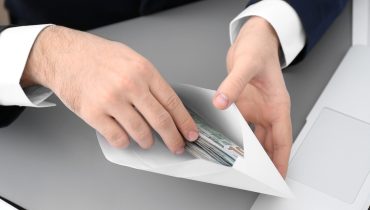 Businessman with bribe at table