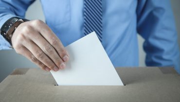 Man putting ballot in election box. Democracy. Freedom
