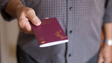 Man holding the Portuguese Passport by hand|Portuguese Passport|Imigração_emigração_imigrantes_emigrantes_Depositphotos_51207545_L|Woman buying tickets with passport at box office