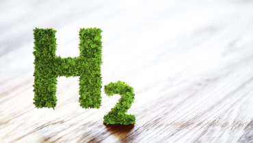 Green hydrogen element sign on blurred wooden background. 3D illustration.