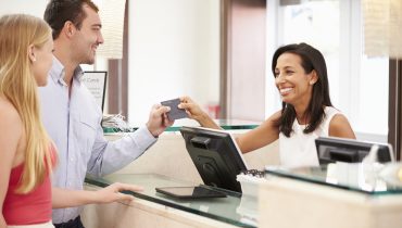 Couple Checking In At Hotel Reception
