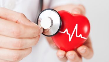 doctor hands holding red heart and stethoscope