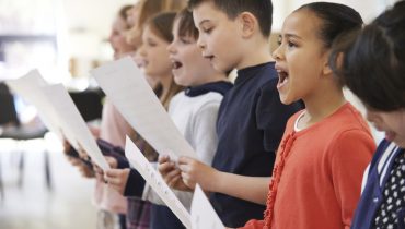 Group Of School Children Singing In Choir Together