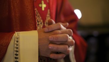 Catholic priest on altar praying during mass